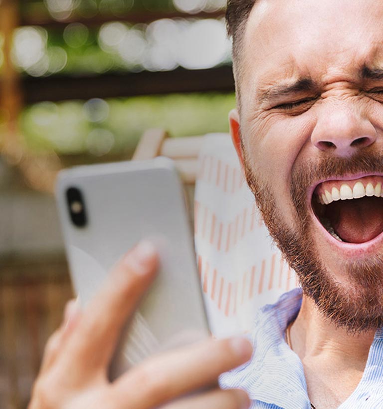 A man with a happy expression holding a phone.